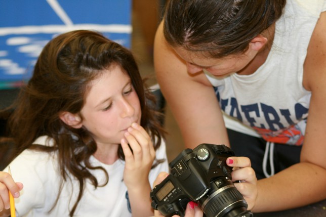 20080717085 Counselor teaching a camper how to use a camera