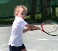 Little girl returning a tennis serve