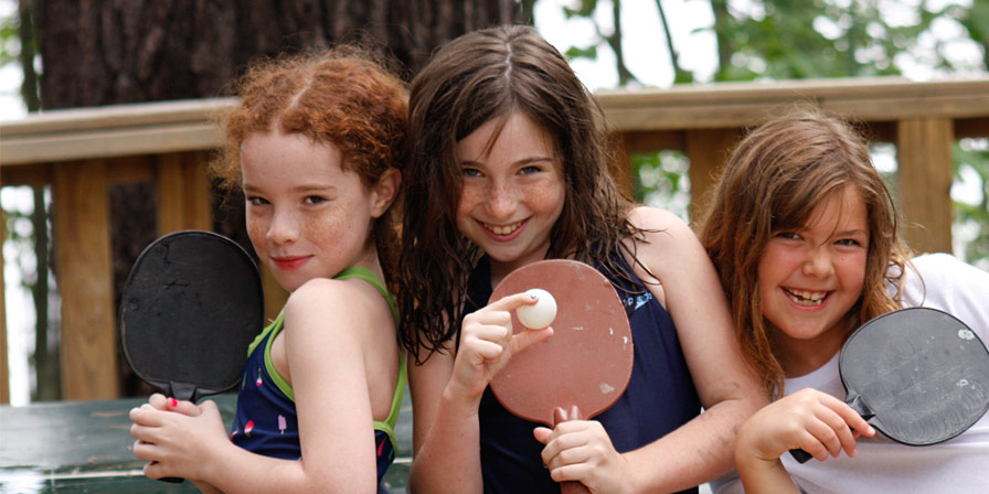 Campers with their ping-pong paddles and a ball.