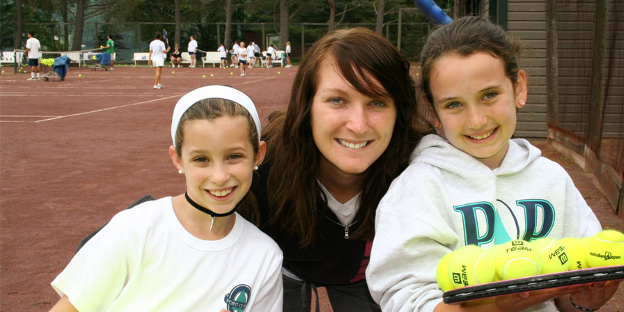 A tennis instructor and two campers on the tennis court
