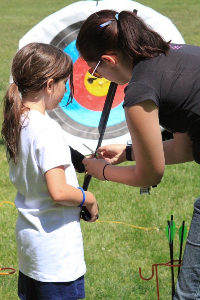 201007021934 An archery counselor teaches a camper to shoot a bow
