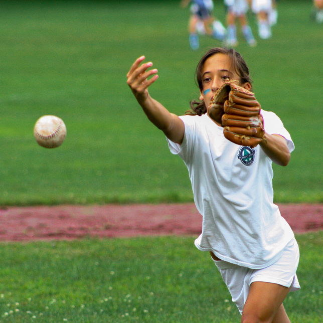 A young camper pitching a softball