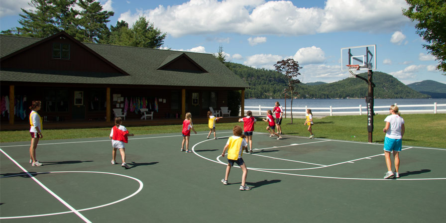 Two teams of campers play a game of basketball.