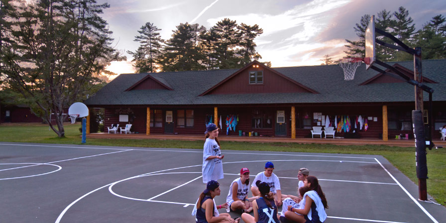 Campers talking and enjoying a beautiful sunset.
