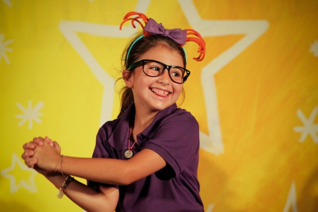 201107304425 Camper smiling on stage in front of a star.