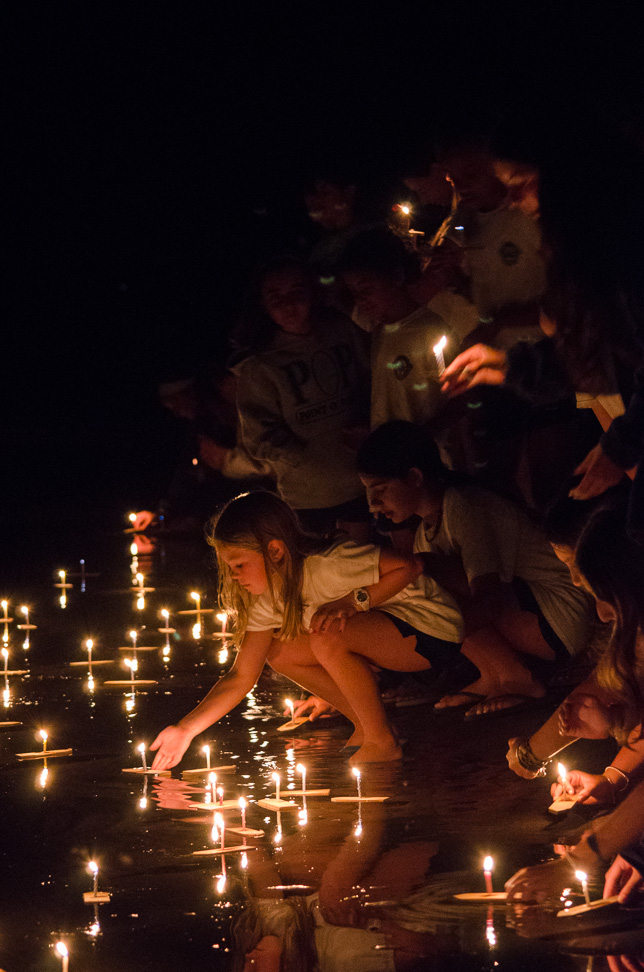 Campers light candles on wish boats