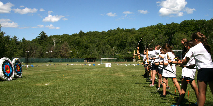 Campers lined up and ready to shoot in an archery class.