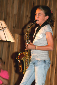 A young camper playing the saxophone