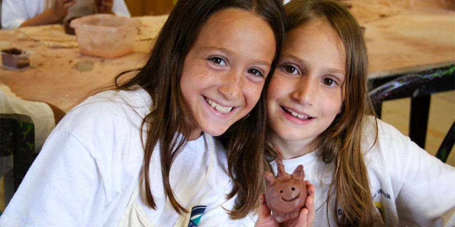Two campers working on a pottery project