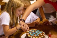 201007292359 A counselor helps a camper cut her birthday cake