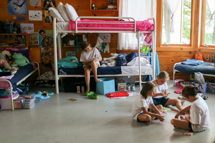 A camper sitting on her bunk writing a letter