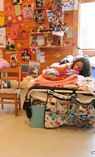 A camper lying on her bunk writing home